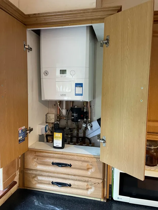 A gas boiler fitted inside a kitchen press, doors open